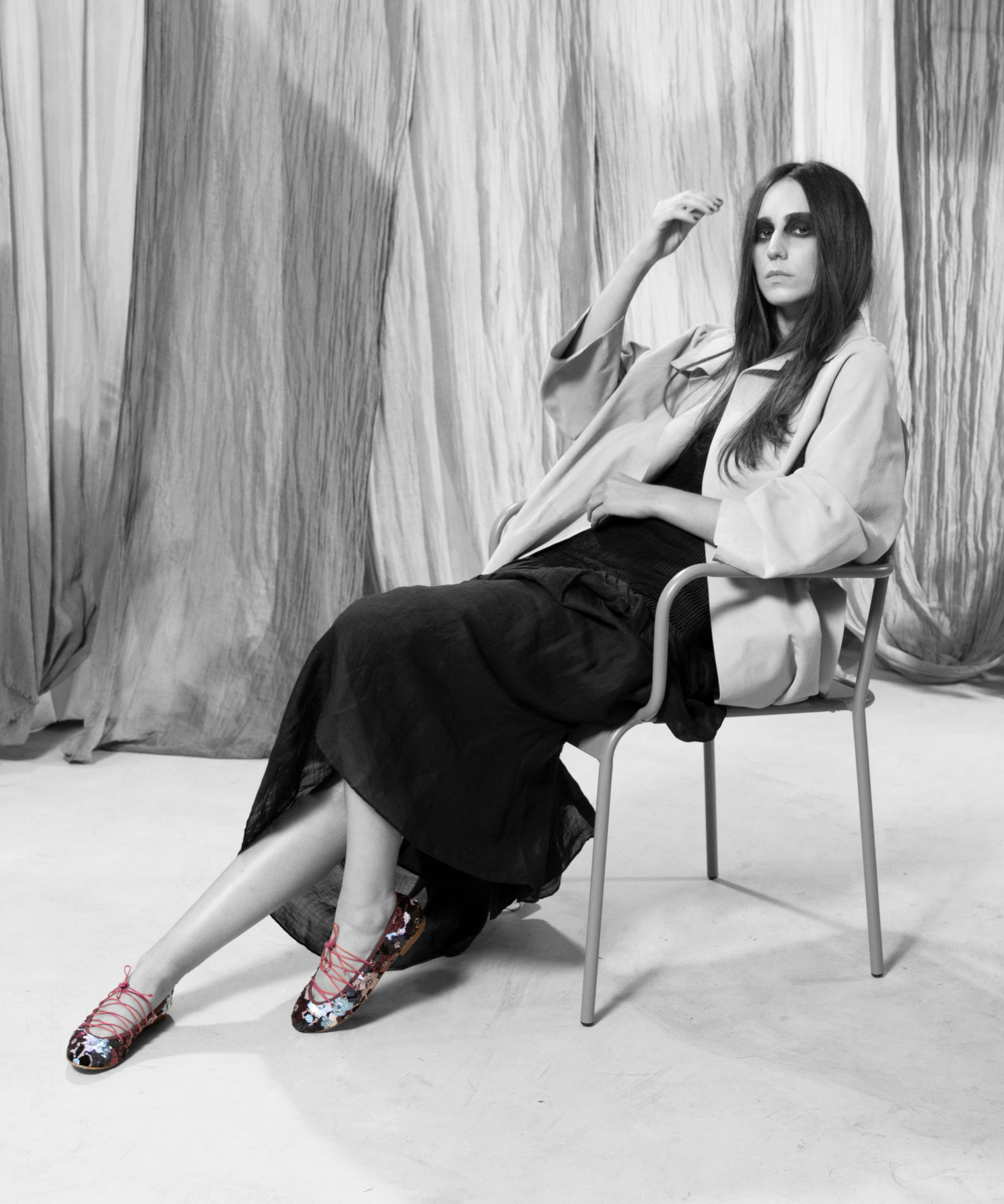 Modelo sentada con Bailarina II Fresa de defloresyfloreros, zapato plano bordado con lentejuelas multicolor y lazada rosa