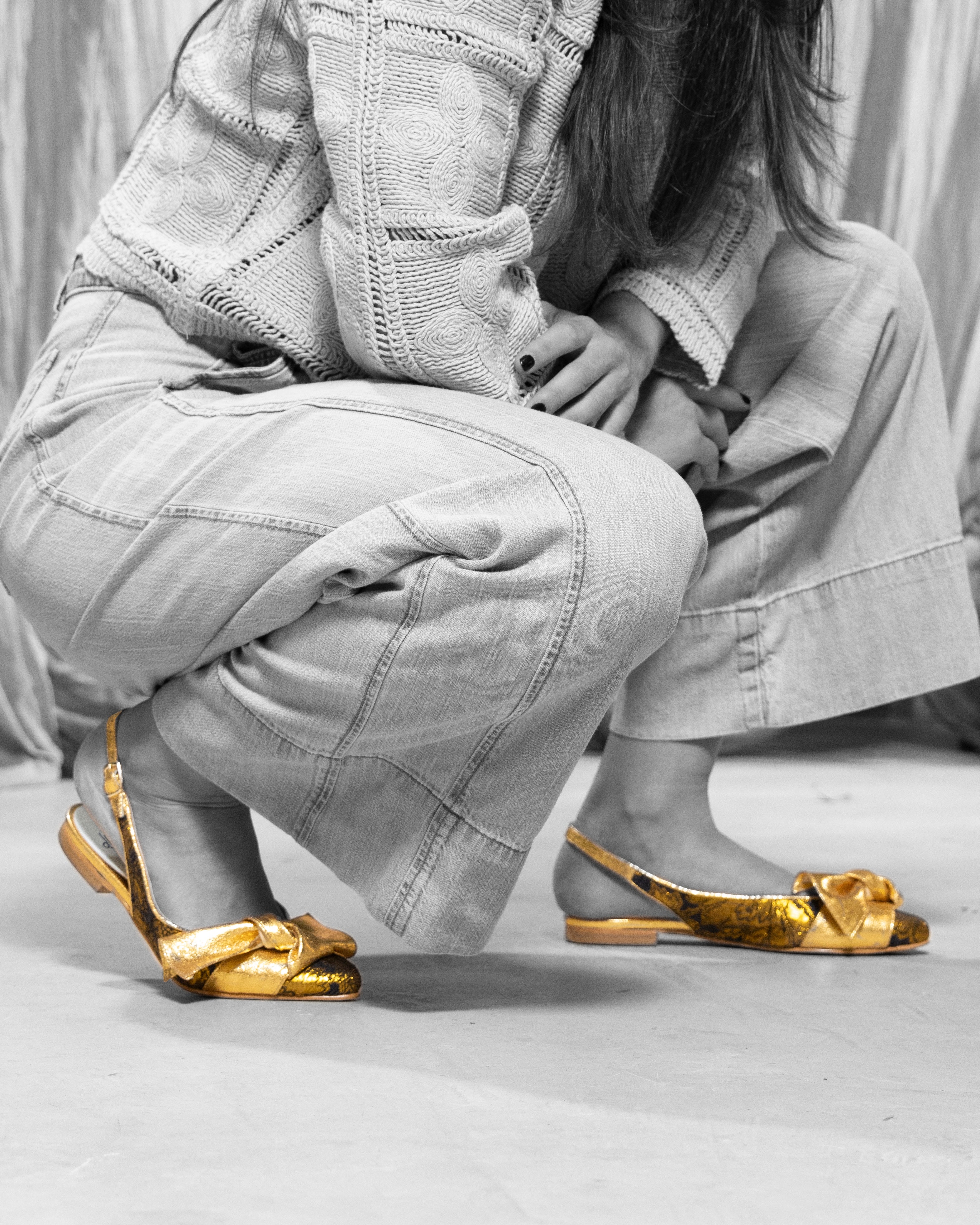 Modelo con Bailarina XI Gold de defloresyfloreros en una imagen editorial en blanco y negro con el zapato dorado destacado