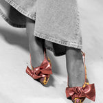 Modelo sentada con Bailarina XI Silo de defloresyfloreros, zapato destalonado artesanal con maxi lazo de piel